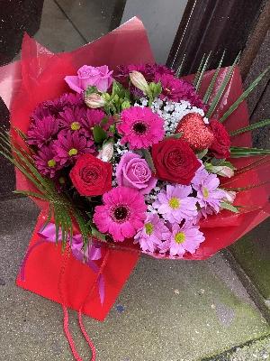 Red roses with rich red and pink toned mixed flowers